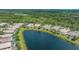 Aerial view of a neighborhood, highlighting a home with a pool nestled by a lake at 7664 Camminare Dr, Sarasota, FL 34238