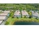 Aerial view of a home with screened pool, mature landscaping, and scenic water views at 7664 Camminare Dr, Sarasota, FL 34238