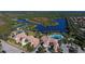 A breathtaking aerial view showcases community amenities: clubhouse, pools, and lake at 7664 Camminare Dr, Sarasota, FL 34238