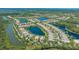 Panoramic aerial view of a serene community with homes bordering a tranquil lake and lush greenery at 7664 Camminare Dr, Sarasota, FL 34238