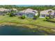 Backyard with screened-in pool overlooking the lake and lush green lawn, perfect for relaxing and entertaining at 7664 Camminare Dr, Sarasota, FL 34238