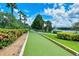 Well-kept bocce ball court surrounded by landscaped hedges, perfect for leisurely outdoor activities at 7664 Camminare Dr, Sarasota, FL 34238