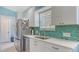 Bright kitchen featuring white cabinets, stainless steel appliances, and ample countertop space at 7664 Camminare Dr, Sarasota, FL 34238