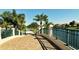 Scenic paved path with manicured landscaping, decorative fencing, and a tranquil waterfront view at 7664 Camminare Dr, Sarasota, FL 34238