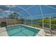 Inviting screened-in pool with clear blue water offering a refreshing oasis and a peaceful view of the surrounding lake at 7664 Camminare Dr, Sarasota, FL 34238