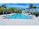 Bright community pool area with lounge chairs and palm trees for a relaxing outdoor experience at 7664 Camminare Dr, Sarasota, FL 34238