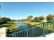 Peaceful waterfront view with lush green landscaping and a glimpse of neighborhood homes at 7664 Camminare Dr, Sarasota, FL 34238
