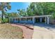 Charming single-story home featuring a covered carport, brick walkway and meticulously landscaped front yard at 826 Lillian Ln, Sarasota, FL 34243