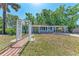 Inviting single-story home with a decorative white archway, and well-maintained landscaping at 826 Lillian Ln, Sarasota, FL 34243
