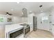 A newly remodeled kitchen features stainless steel appliances, quartz countertops, and sleek white cabinets at 826 Lillian Ln, Sarasota, FL 34243