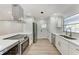 Modern kitchen with stainless steel appliances, white cabinets, and a sleek cooktop on the island at 826 Lillian Ln, Sarasota, FL 34243