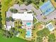 Aerial view of a community center featuring pools, a hot tub, and a tennis court surrounded by trees at 8534 Imperial Cir, Palmetto, FL 34221