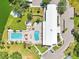 Aerial view of a community center featuring pools, a hot tub, and a tennis court surrounded by lush landscaping at 8534 Imperial Cir, Palmetto, FL 34221