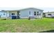 Exterior view of backyard featuring a well-maintained lawn, exterior features, and air conditioning unit at 8534 Imperial Cir, Palmetto, FL 34221