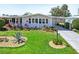 Charming single-story home featuring a lush lawn with tropical plants and a convenient covered carport at 8534 Imperial Cir, Palmetto, FL 34221