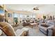 Bright and airy living room featuring large windows, comfortable seating, and a ceiling fan at 8534 Imperial Cir, Palmetto, FL 34221