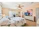 Well-lit main bedroom with a ceiling fan, dresser, and a view of the outside at 8534 Imperial Cir, Palmetto, FL 34221