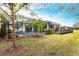 Backyard featuring a screened-in pool, lush lawn, and mature trees at 1007 143Rd Ne St, Bradenton, FL 34212
