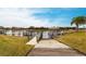 Concrete boat ramp with a dock offering access to a tranquil waterfront, with boat lift and scenic surroundings at 1007 143Rd Ne St, Bradenton, FL 34212