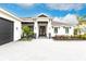 Beautiful home featuring a manicured lawn, covered front porch, and elegant exterior lighting at 1007 143Rd Ne St, Bradenton, FL 34212