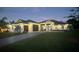 Stunning home featuring a wide driveway, two-car garage, and immaculate landscaping at dusk at 1007 143Rd Ne St, Bradenton, FL 34212
