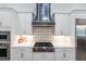 Close-up of a luxury kitchen with white cabinets, stainless steel appliances, and a stylish backsplash at 1007 143Rd Ne St, Bradenton, FL 34212