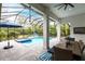 Screened-in pool with brick pavers, a dining table, and blue umbrellas at 1007 143Rd Ne St, Bradenton, FL 34212