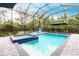 Screened-in pool with an in-ground spa, clear water, and brick pavers at 1007 143Rd Ne St, Bradenton, FL 34212