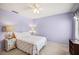 Bedroom with a carpeted floor, light purple walls, and a queen bed with a nightstand at 1111 W Faith Cir # 2004, Bradenton, FL 34212