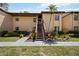 Charming two-story condo building with lush landscaping, a walkway, and a palm tree at 1111 W Faith Cir # 2004, Bradenton, FL 34212