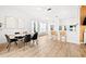 Open-concept kitchen and dining area with hardwood floors, bar seating, and modern light fixtures at 1189 Fraser Pine Blvd, Sarasota, FL 34240