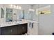 Modern bathroom featuring double sinks, a glass-enclosed shower, and sleek fixtures at 12272 Stuart Dr, Venice, FL 34293