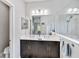 Bright bathroom featuring double sinks, dark cabinets, and a walk-in shower with glass enclosure at 12272 Stuart Dr, Venice, FL 34293