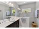 Well-lit bathroom featuring a double sink vanity, a glass-enclosed shower, and neutral decor at 12272 Stuart Dr, Venice, FL 34293