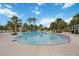 Large community pool with surrounding lounge chairs, palm trees, and a slide, perfect for relaxation and recreation at 12272 Stuart Dr, Venice, FL 34293