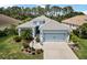 Charming single-story home featuring a well-manicured lawn, elegant landscaping, and a two-car garage at 12272 Stuart Dr, Venice, FL 34293
