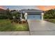 Charming single-story home featuring a well-manicured lawn, elegant landscaping, and a two-car garage at 12272 Stuart Dr, Venice, FL 34293
