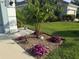 Lush landscaping features a small palm tree surrounded by colorful flowers and mulch at 12272 Stuart Dr, Venice, FL 34293