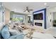 Cozy living room with a fireplace, large window, and comfortable sofas perfect for relaxing at 12272 Stuart Dr, Venice, FL 34293