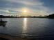 Scenic view of a tranquil pond reflecting the sunset with a wooden dock at 12272 Stuart Dr, Venice, FL 34293