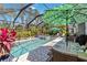 Inviting pool area with lush landscaping, sun loungers, and a dining table, perfect for outdoor enjoyment at 12272 Stuart Dr, Venice, FL 34293