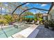 Inviting screened pool area featuring a spa, lounge chairs, and lush landscaping, creating a tranquil retreat at 12272 Stuart Dr, Venice, FL 34293