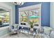 Bright sitting area featuring a large window view of the pool area and tropical landscaping at 12272 Stuart Dr, Venice, FL 34293
