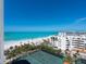Scenic aerial view of the beach, tennis courts, and beachfront condos on a clear day at 1281 Gulf Of Mexico Dr # 704, Longboat Key, FL 34228