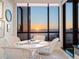 Bright breakfast nook with ocean views, featuring a glass table and stylish white wicker chairs at 1281 Gulf Of Mexico Dr # 704, Longboat Key, FL 34228