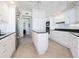 Spacious kitchen with an island, granite countertops, stainless steel appliances, and white cabinets at 1281 Gulf Of Mexico Dr # 704, Longboat Key, FL 34228