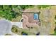 Aerial of a home's rooftop, backyard pool with screened enclosure, and expansive green lawn space at 15107 3Rd E Dr, Bradenton, FL 34212