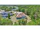 Aerial view of a home's backyard with pool, surrounded by lush trees, and a lake in the distance at 15107 3Rd E Dr, Bradenton, FL 34212