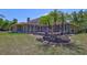 Landscaped backyard with a screened-in patio, lighting, and palm trees at 15107 3Rd E Dr, Bradenton, FL 34212