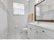 Well-lit bathroom with white cabinets, a large mirror, and shower with decorative curtain at 15107 3Rd E Dr, Bradenton, FL 34212
